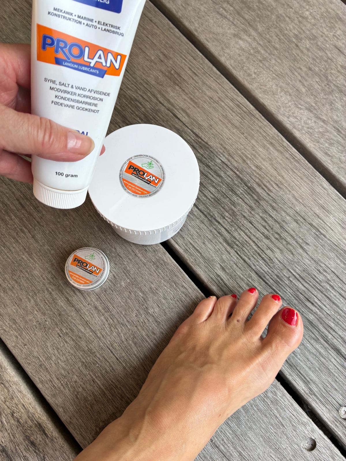 Prolan Care Grease balsem naast een verzorgde voet, ideaal voor droge hielen en kloven.